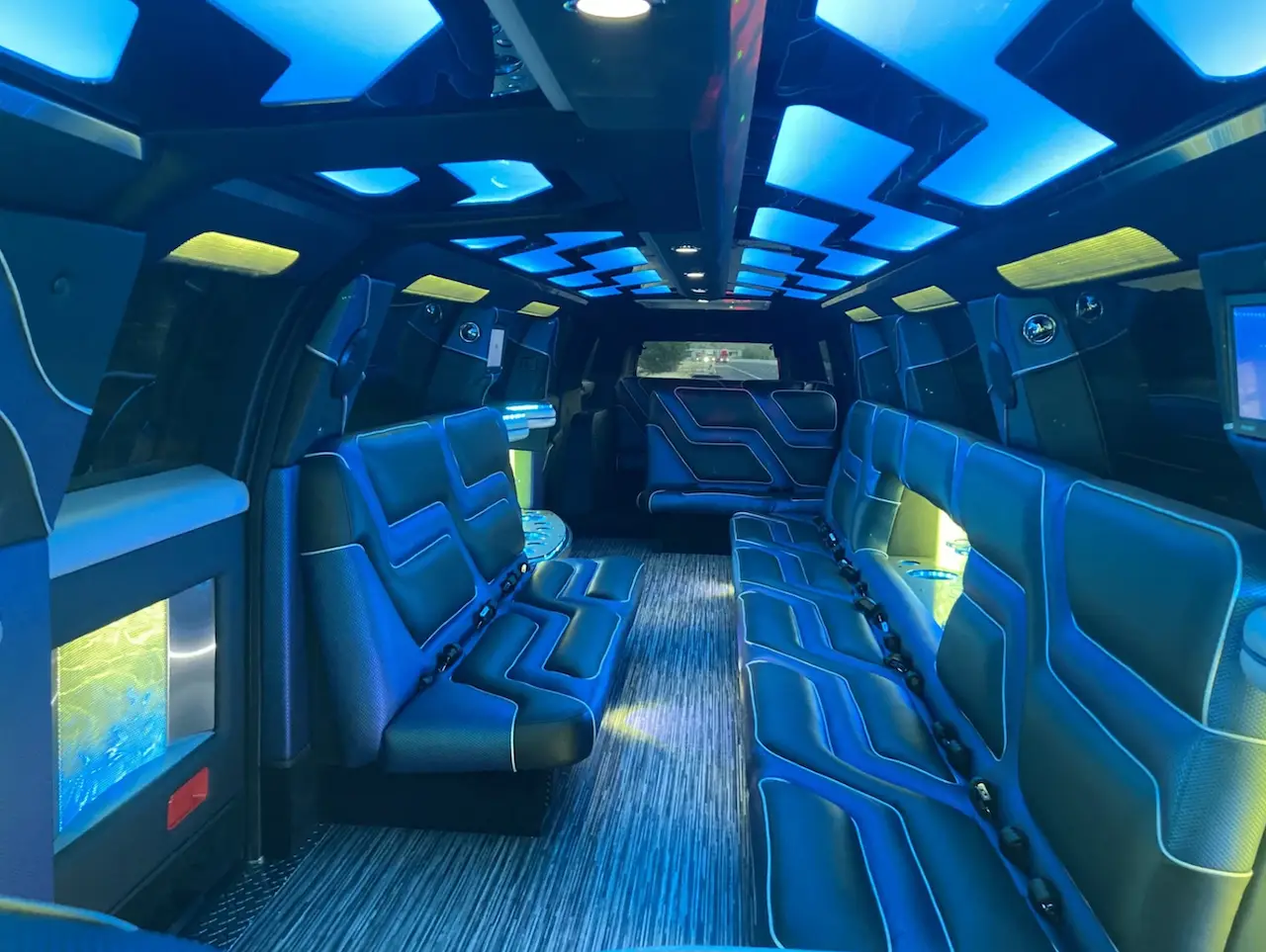 Interior of 2024 Cadillac Escalade Stretch Limousine with ambient LED lighting, luxury leather seating, and entertainment features by Basking Ridge Limousine Services.