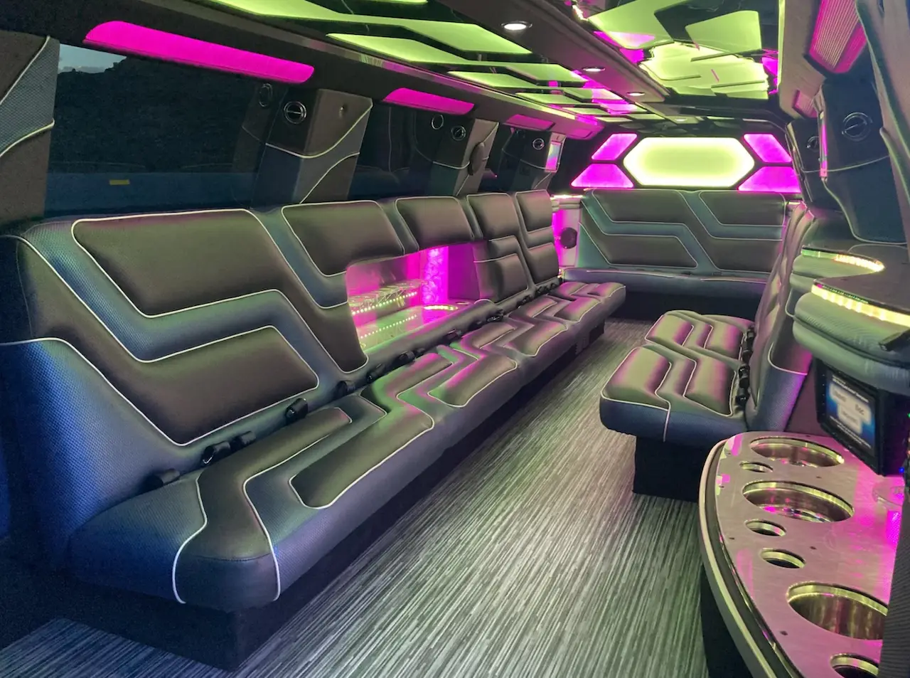 Interior view of Cadillac Escalade Stretch Limousine with custom LED lighting, leather wraparound seating, and built-in drink bar by Basking Ridge Limousine Services.