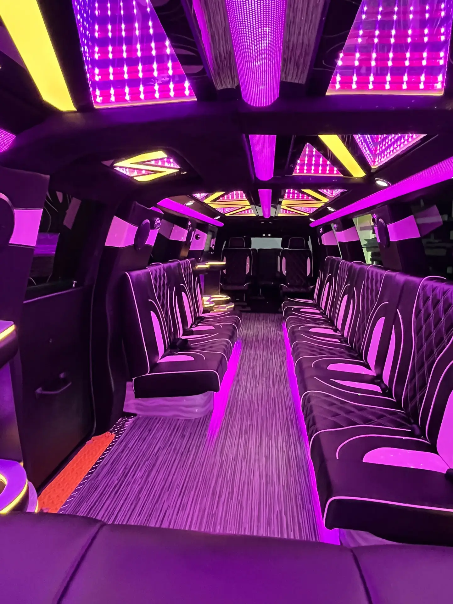 Interior view of Basking Ridge Limousine's 2025 GMC Yukon Stretch Limo featuring luxury leather seating, LED lighting, and a vibrant party ambiance.