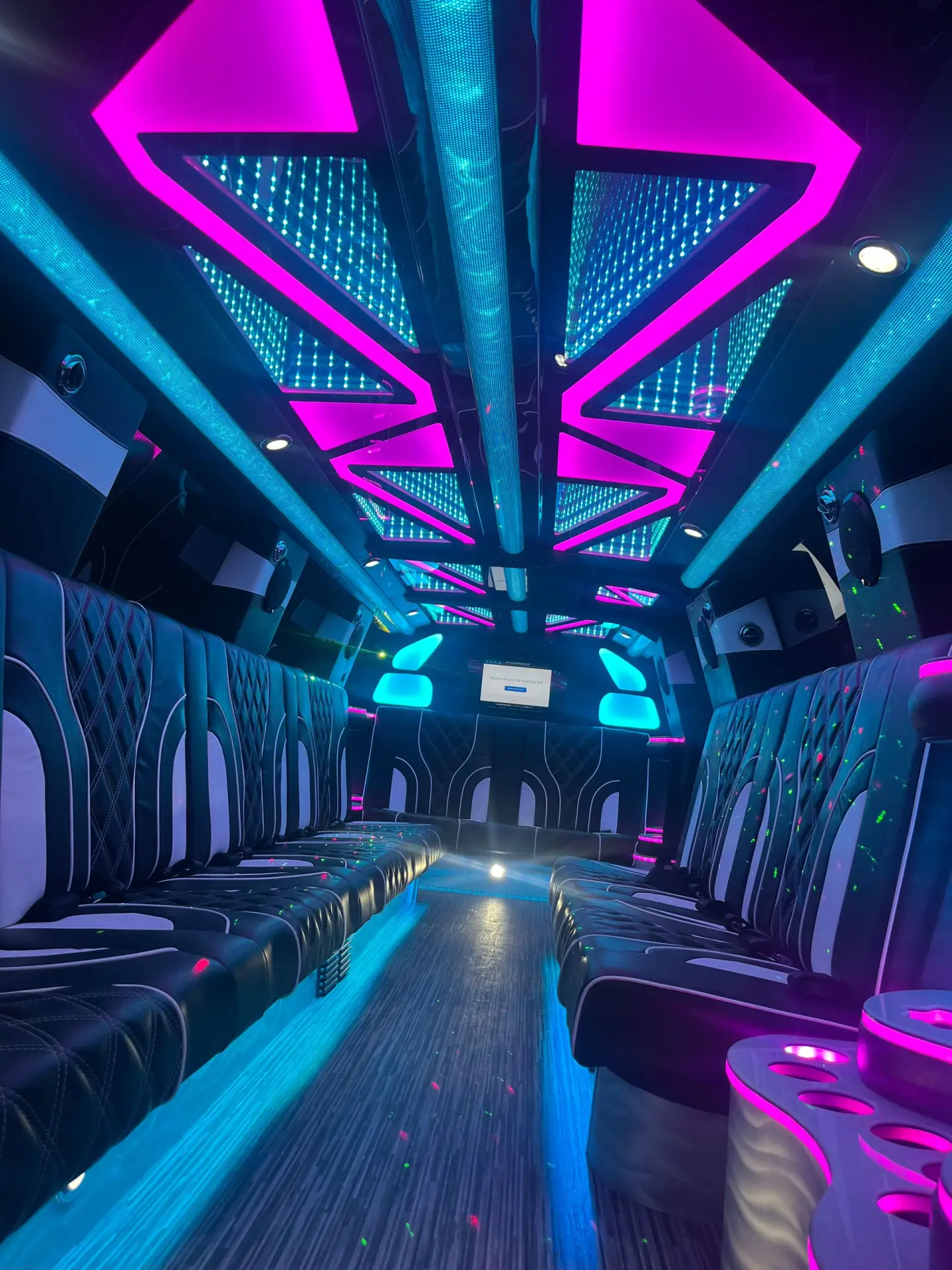 Vibrant interior of Basking Ridge Limousine’s 2025 GMC Yukon Stretch Limo with LED-lit ceiling, premium leather seats, and modern ambiance lighting.