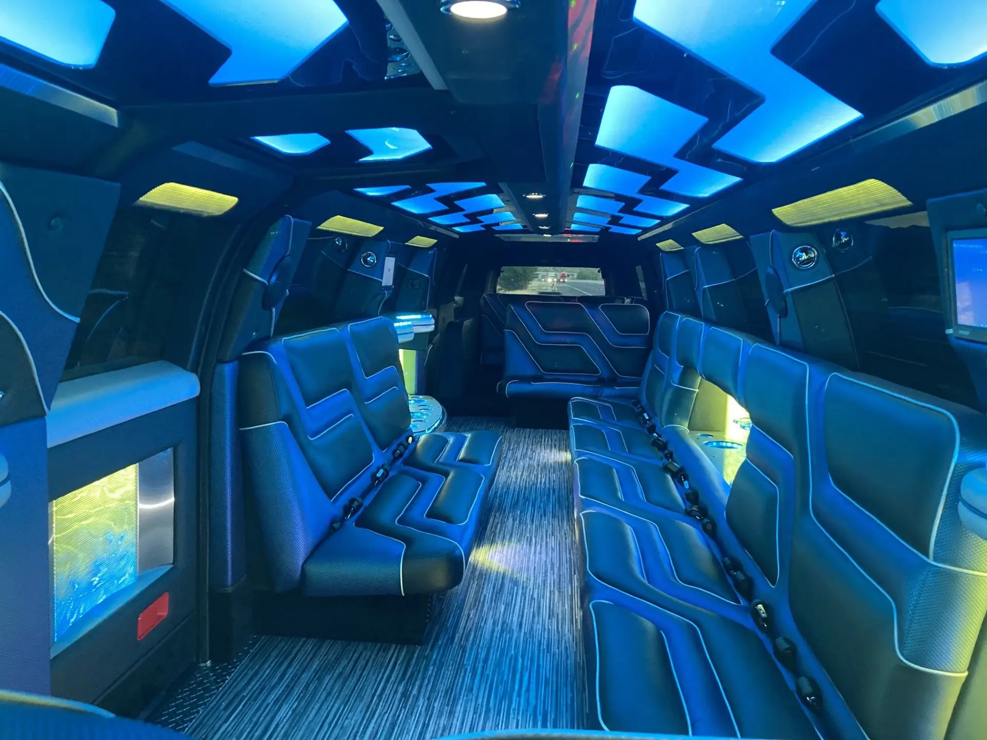Interior of 2024 Cadillac Escalade Stretch Limousine with ambient LED lighting, luxury leather seating, and entertainment features by Basking Ridge Limousine Services.