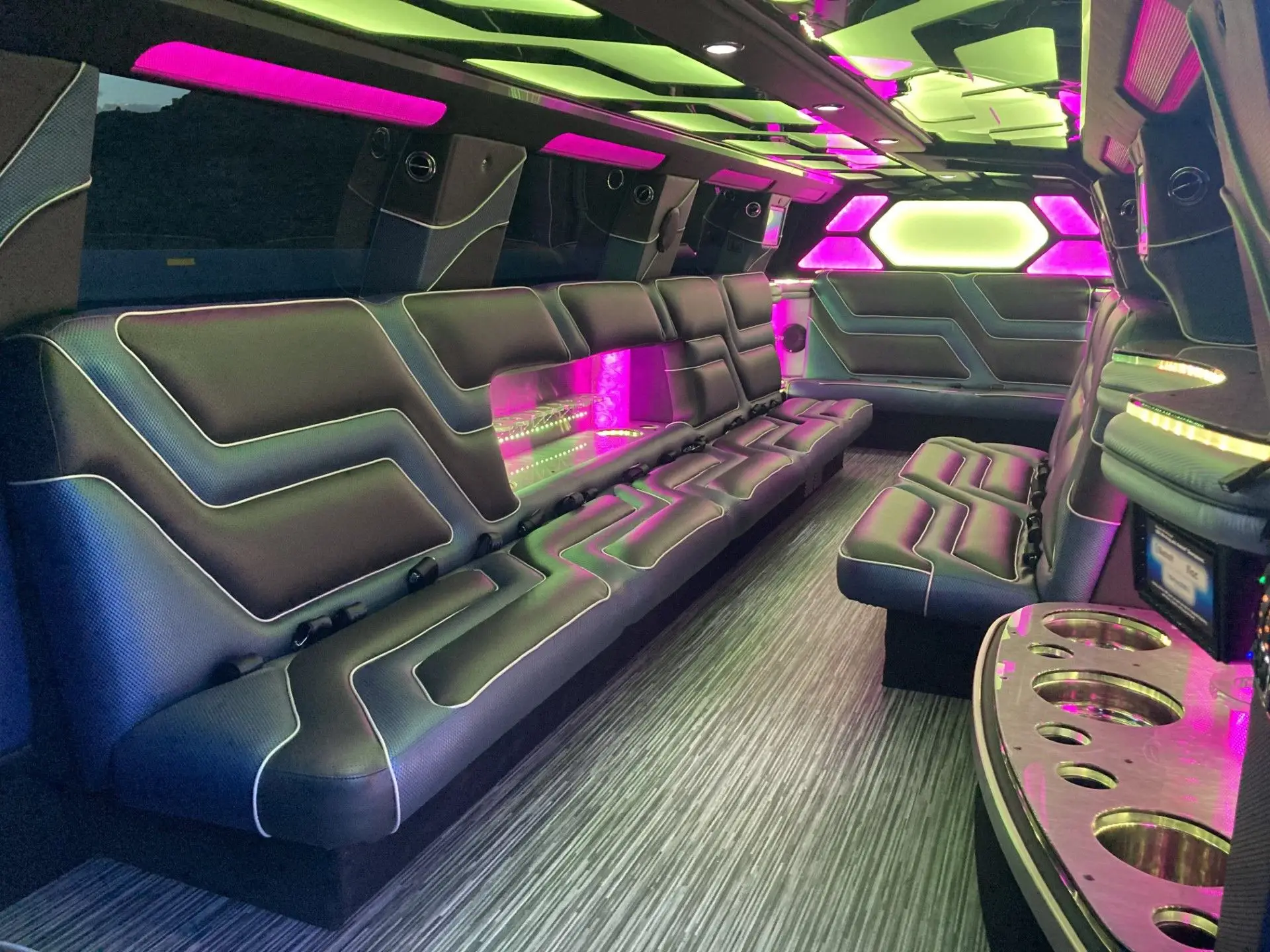 Interior view of Cadillac Escalade Stretch Limousine with custom LED lighting, leather wraparound seating, and built-in drink bar by Basking Ridge Limousine Services.