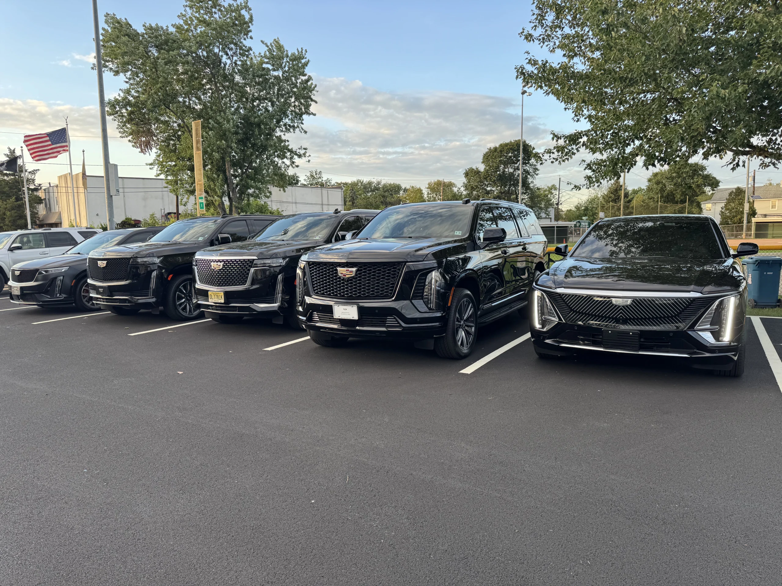 Black Cadillac SUV fleet staged and ready with American flag โ Basking Ridge Limousine ground transportation built for aviation companies