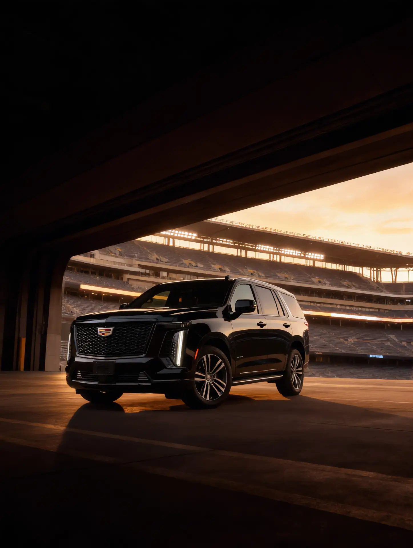 Chauffeured Cadillac Escalade luxury SUV at stadium tunnel entrance during sunset — sports event limousine service in New Jersey by Basking Ridge Limousine
