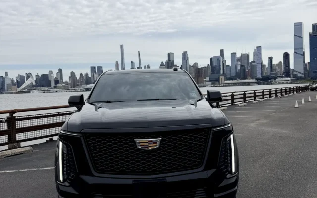 2025 Cadillac Escalade Platinum SUV front view at Hudson waterfront with Manhattan skyline — Basking Ridge Limousine NJ