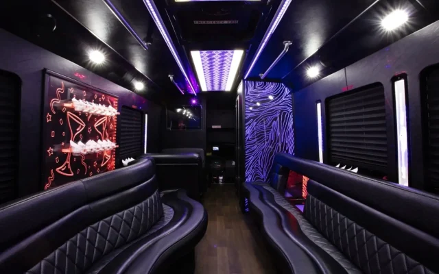 Interior of 25-passenger party bus with black leather seating and LED lighting