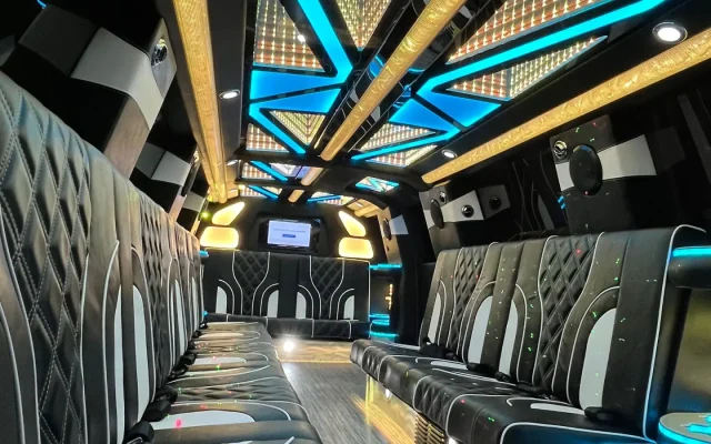 Interior of Basking Ridge Limousine's 2025 GMC Yukon Stretch Limo featuring black diamond-stitched leather seating, blue LED ceiling lights, and luxury party-style ambiance.