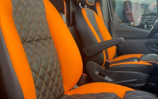 Maybach logo embossed headrests and orange diamond-stitched leather chauffeur seats inside 2025 Mercedes Sprinter Maybach limo party bus — Basking Ridge Limousine Services NJ