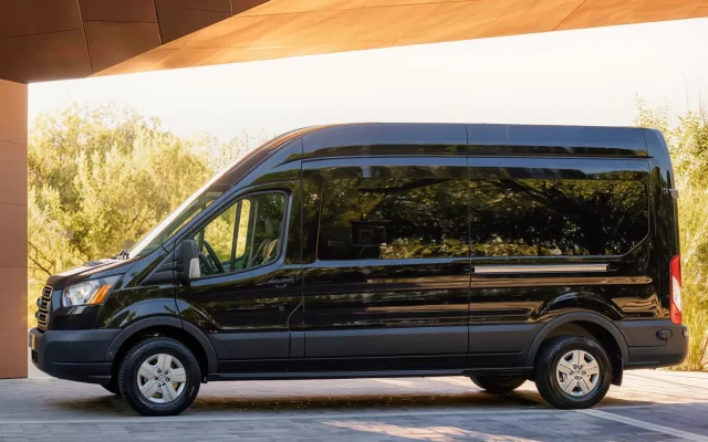 Side profile of a black high-top 14 passenger Ford Transit van for NJ group transportation