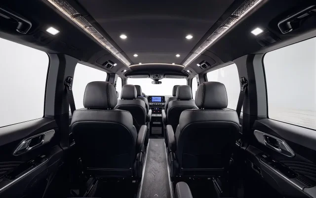 Black leather seating layout inside a 14 passenger Ford Transit van