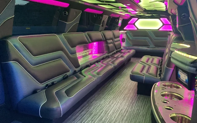 Interior view of Cadillac Escalade Stretch Limousine with custom LED lighting, leather wraparound seating, and built-in drink bar by Basking Ridge Limousine Services.