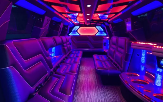 Interior of Cadillac Escalade Stretch Limousine with red and blue LED lights, luxury leather seating, and party-ready ambiance by Basking Ridge Limousine Services.
